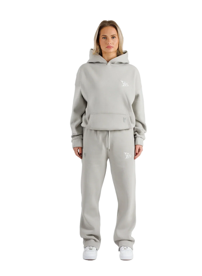 Woman wearing a gray tracksuit with a brand logo on a white background