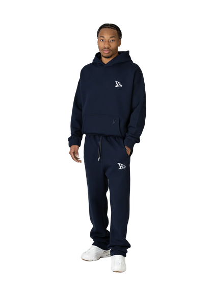 Person wearing a navy tracksuit with a logo on a white background