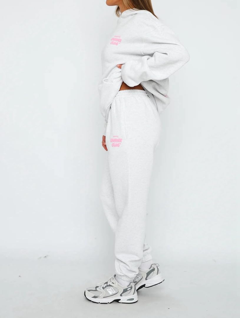 Person wearing a white tracksuit with pink accents on a white background