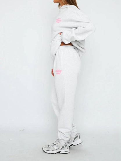 Person wearing a white tracksuit with pink accents on a white background