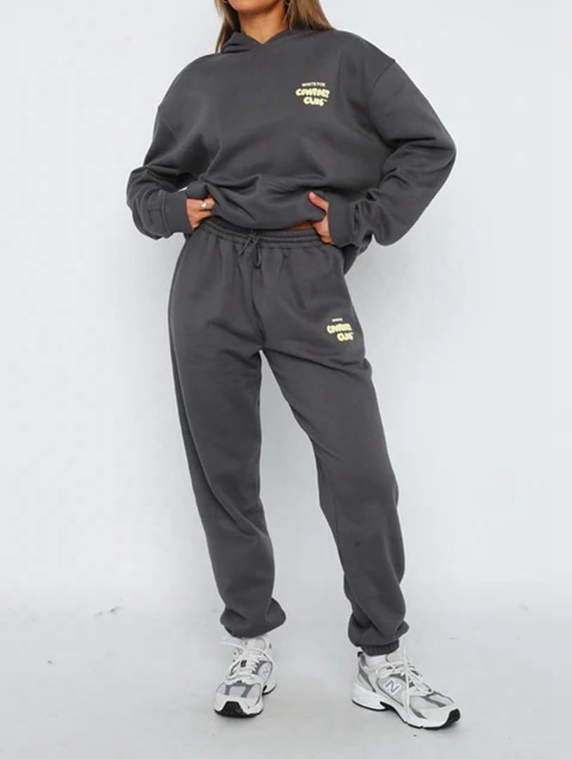 Person wearing a gray sweatshirt and pants set with brand logo on a white background