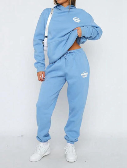 Person wearing a blue tracksuit with white branding on a white background