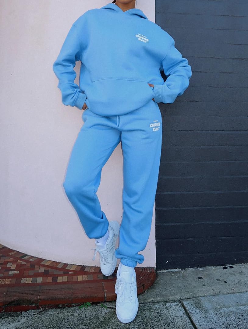 Person wearing a blue tracksuit with visible branding against a wall.
