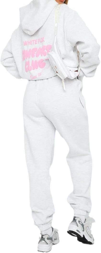 White tracksuit with pink text on the back, worn by a person.