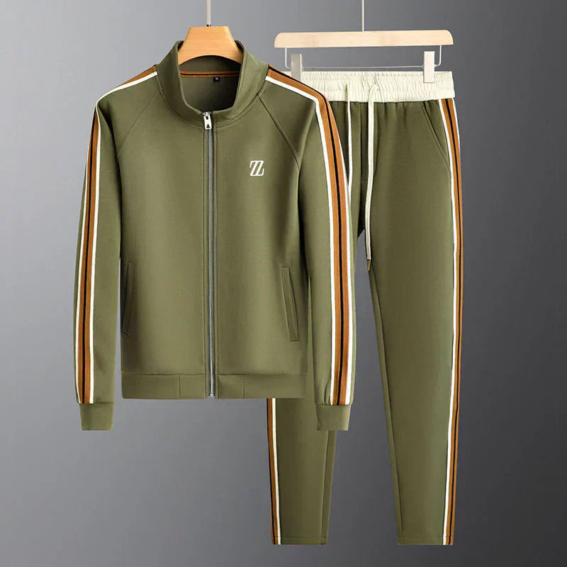 Green tracksuit with side stripes on hangers against a gray background