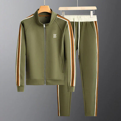 Green tracksuit with side stripes on hangers against a gray background