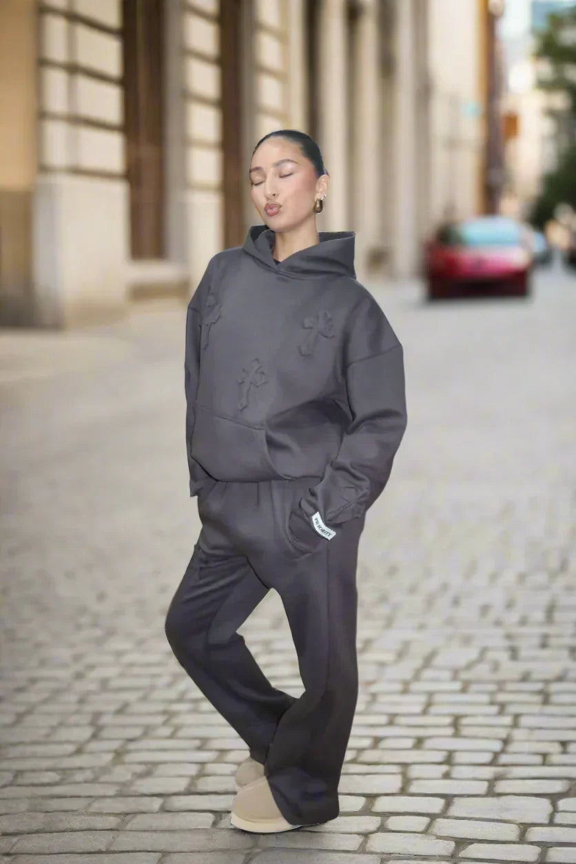 Person wearing a dark gray outfit on a city street.