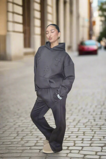 Person wearing a dark gray outfit on a city street.