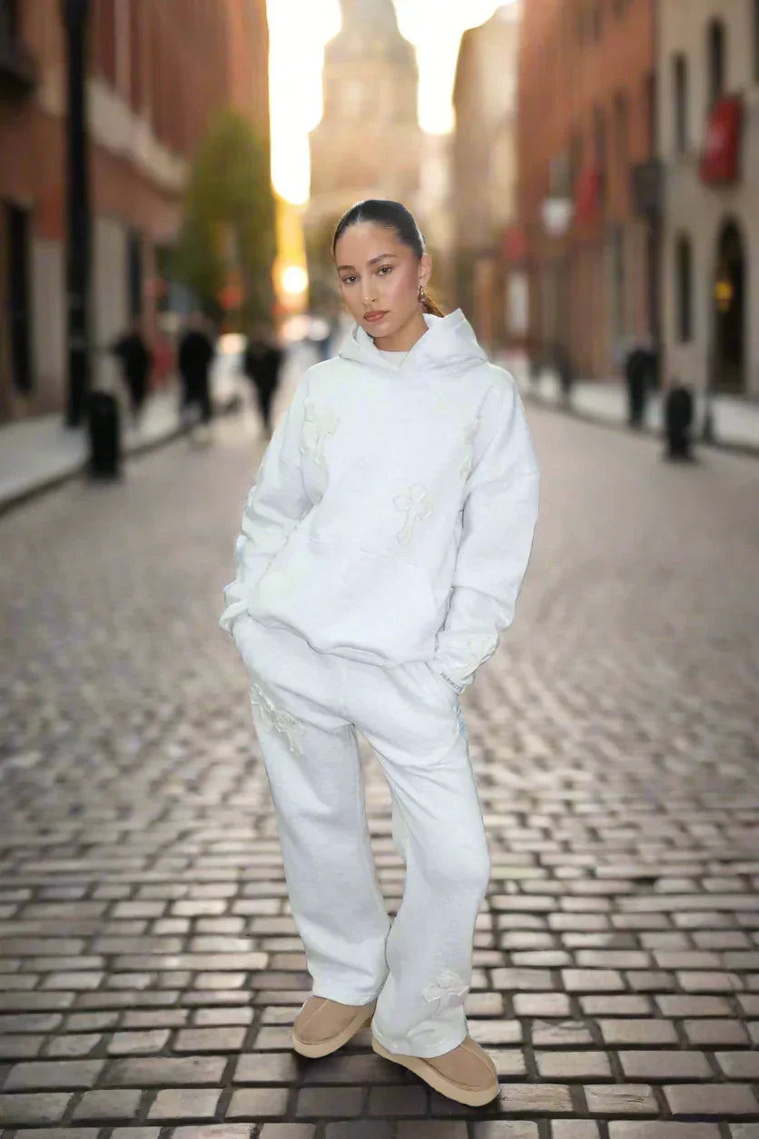 Person wearing a white outfit standing on a city street.