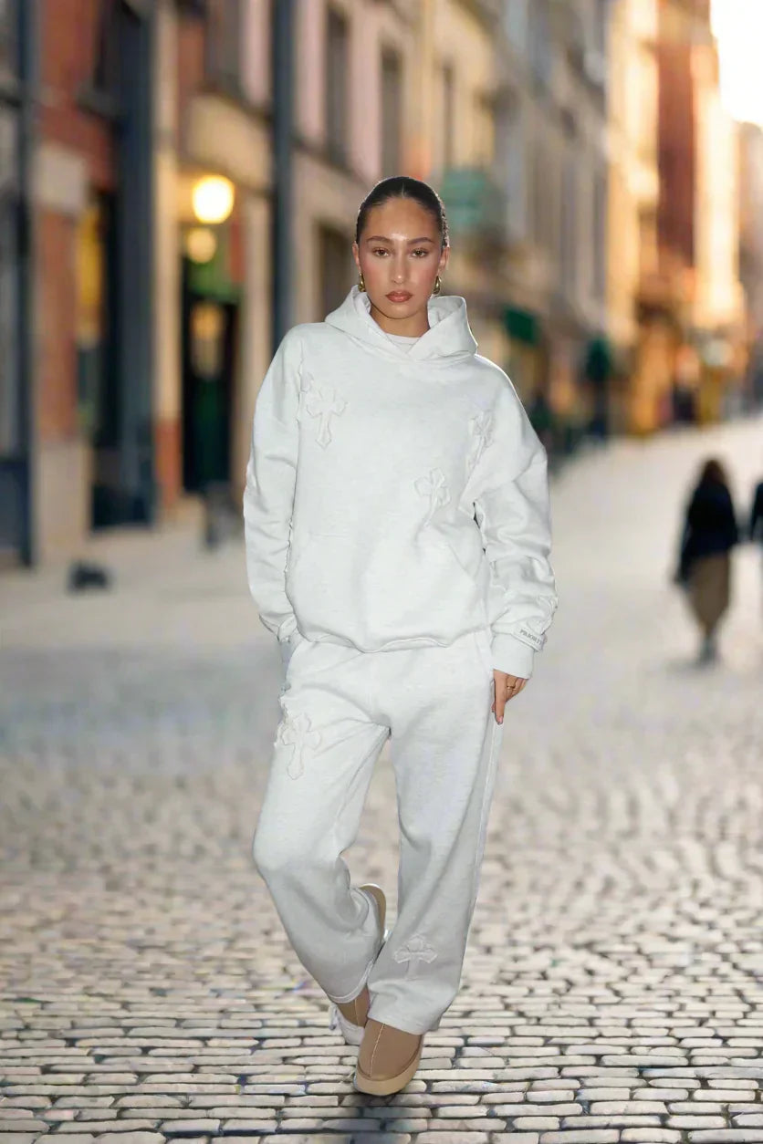 Person wearing a white outfit walking on a city street.