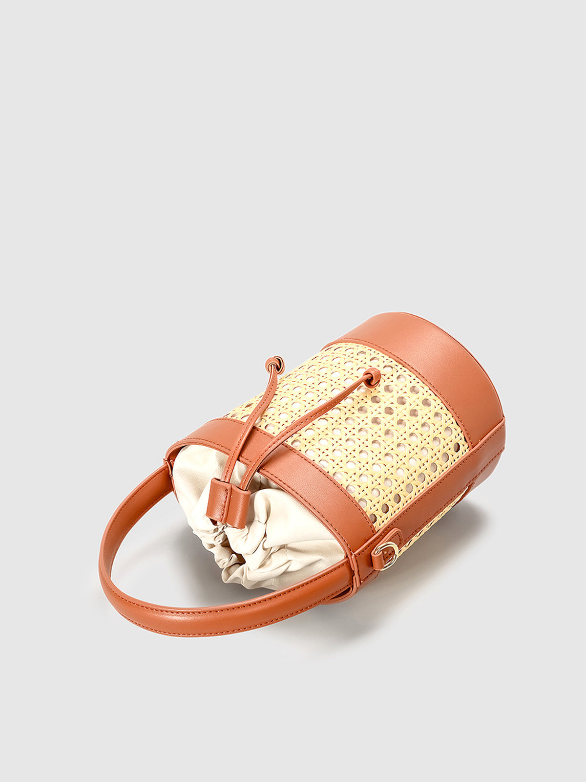 Bolso tipo cubo con cordón y acento de ratán