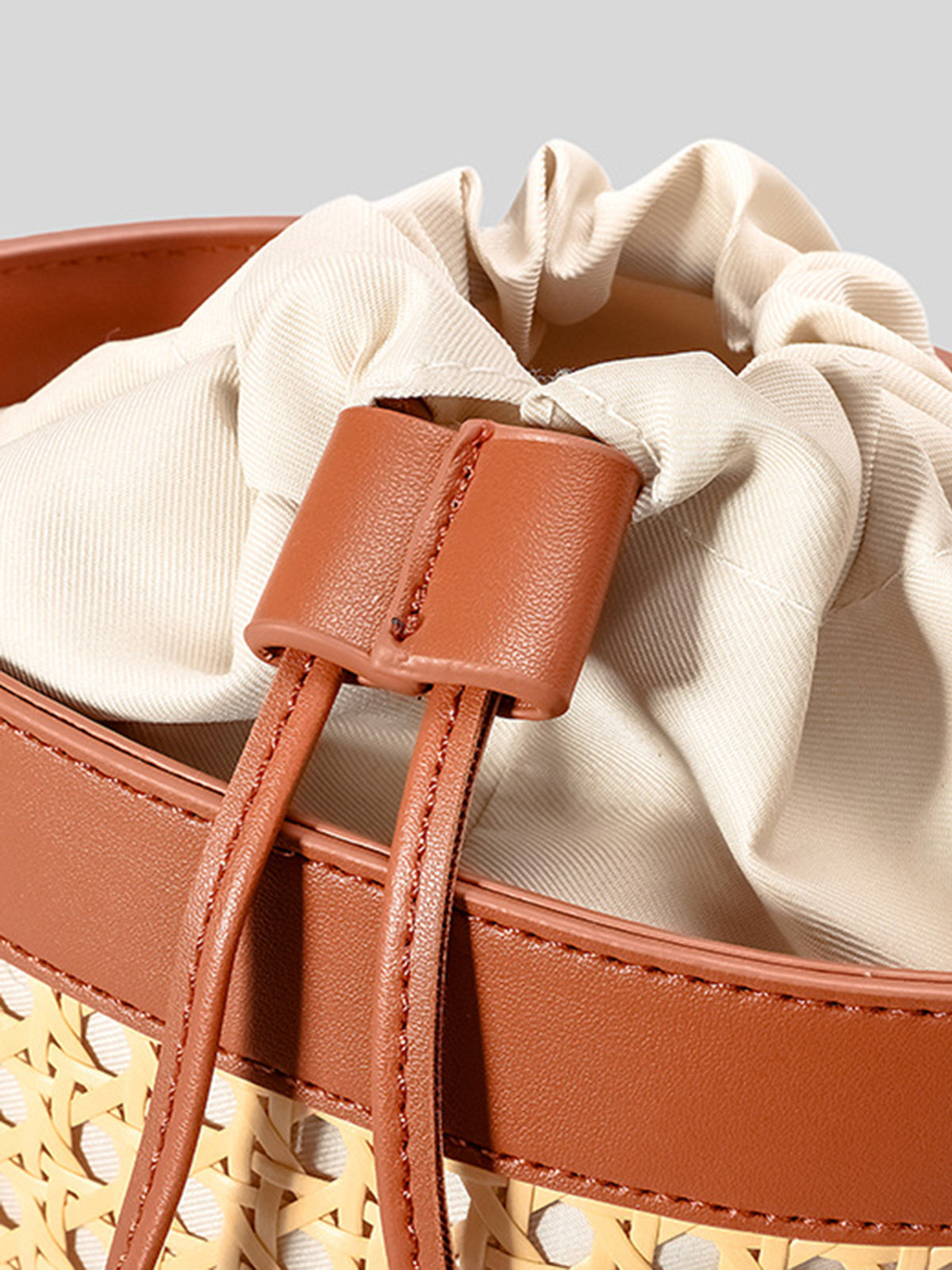 Bolso tipo cubo con cordón y acento de ratán